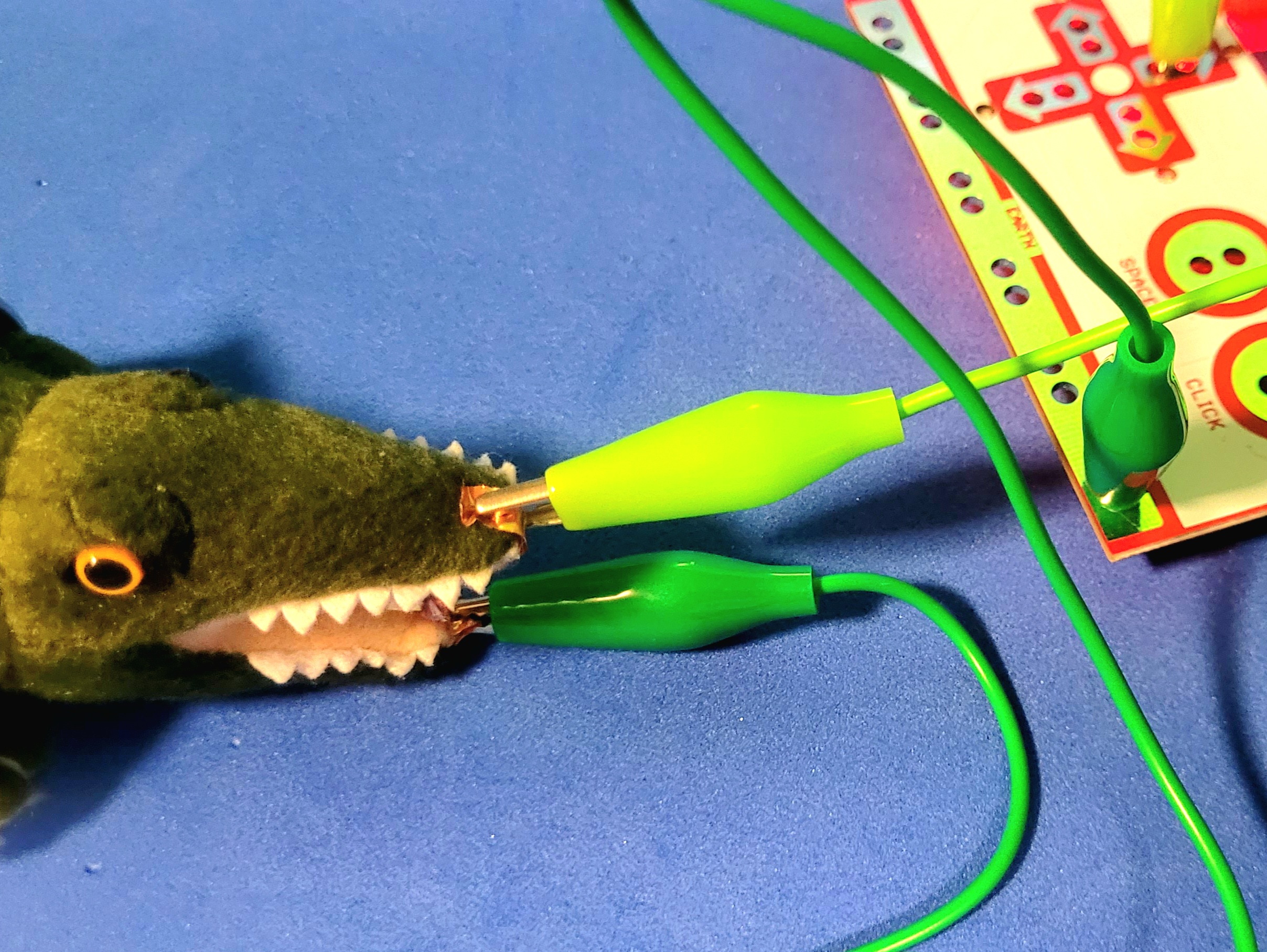 A photo of an alligator plush connected with copper tape to the MakeyMakey